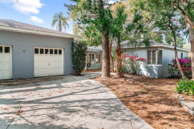 ranch-style house with stucco siding, concrete driveway, and an attached garage