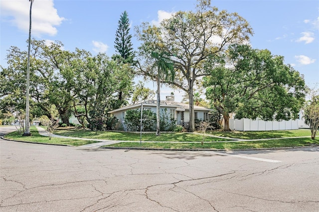 view of front of house featuring a chimney, a front lawn, and fence