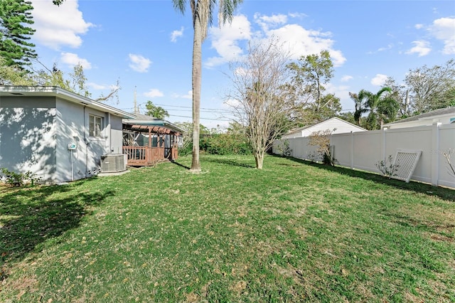 view of yard with a fenced backyard, a gazebo, and central AC