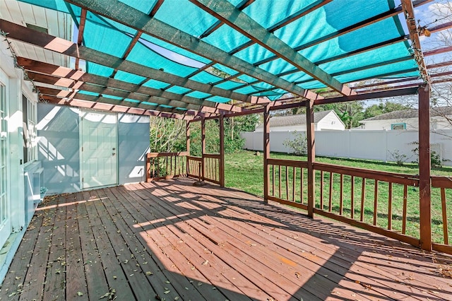 deck featuring a lawn, a pergola, and fence