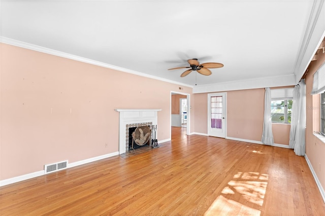 unfurnished living room featuring visible vents, light wood-style flooring, ornamental molding, baseboards, and a brick fireplace