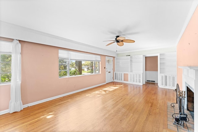 unfurnished living room featuring visible vents, baseboards, ornamental molding, a fireplace, and light wood-style floors