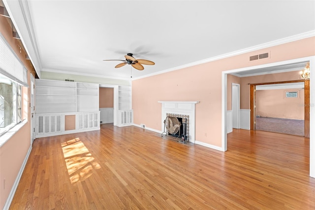 unfurnished living room featuring visible vents, a fireplace with flush hearth, light wood-style flooring, and crown molding