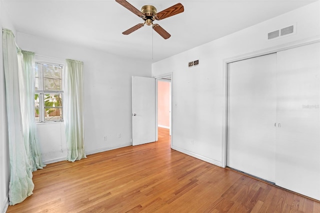 unfurnished bedroom with visible vents, a closet, light wood finished floors, baseboards, and ceiling fan