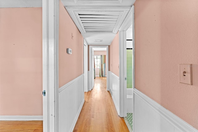 hall featuring wainscoting and light wood-style flooring