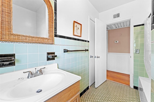 full bathroom with visible vents, curtained shower, vanity, and a wainscoted wall