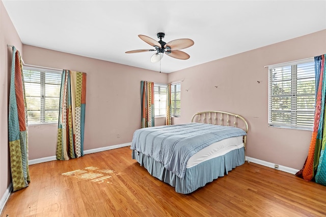 bedroom featuring a ceiling fan, baseboards, and light wood-type flooring