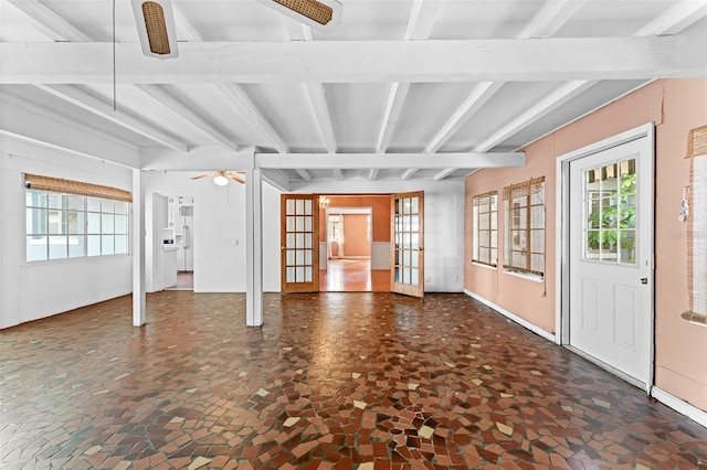 interior space with beamed ceiling, a healthy amount of sunlight, french doors, and a ceiling fan