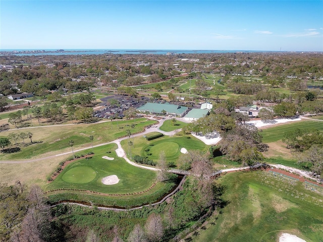 birds eye view of property with golf course view and a water view