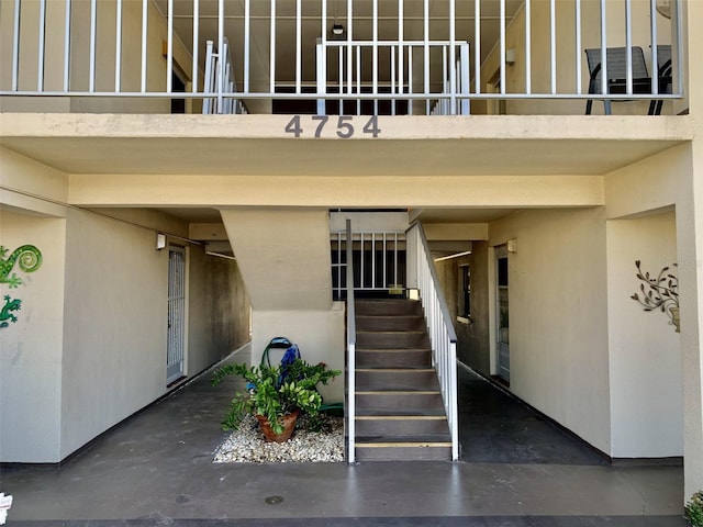 doorway to property with stucco siding and a balcony