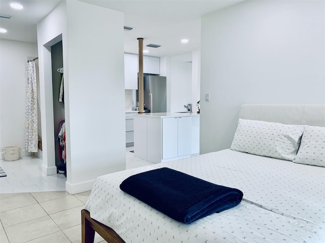 bedroom featuring light tile patterned floors, baseboards, recessed lighting, freestanding refrigerator, and a sink