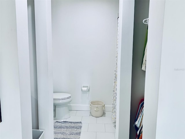 bathroom featuring tile patterned flooring, toilet, and baseboards
