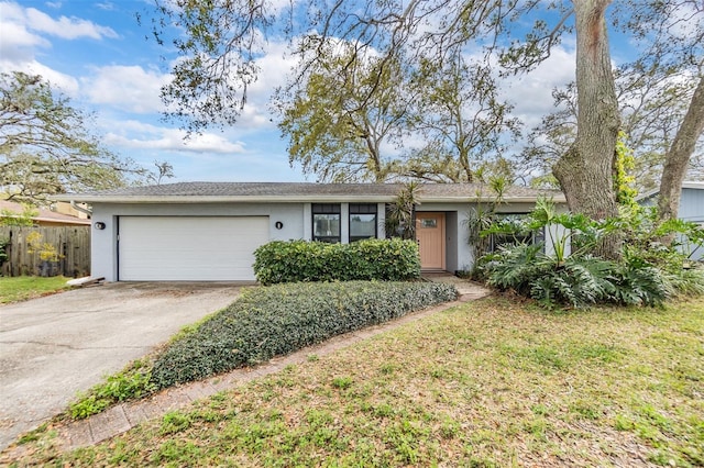 single story home with a front lawn, fence, concrete driveway, stucco siding, and an attached garage