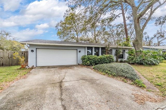 single story home with stucco siding, concrete driveway, a garage, and fence