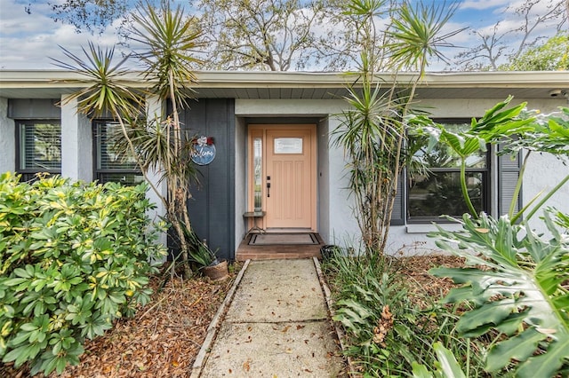 entrance to property featuring stucco siding