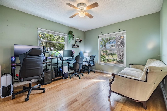 office area featuring a healthy amount of sunlight, a textured ceiling, and wood finished floors