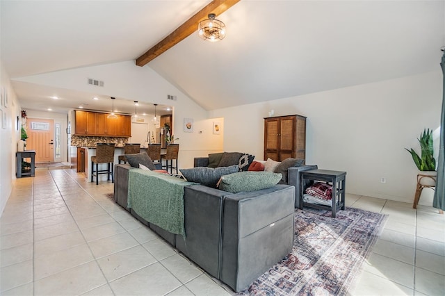 living area featuring light tile patterned flooring, visible vents, beamed ceiling, and high vaulted ceiling