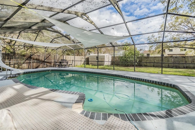 view of pool featuring glass enclosure, a fenced in pool, a water slide, a fenced backyard, and a patio area