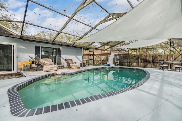 view of swimming pool featuring a patio area, a fenced in pool, a water slide, and fence