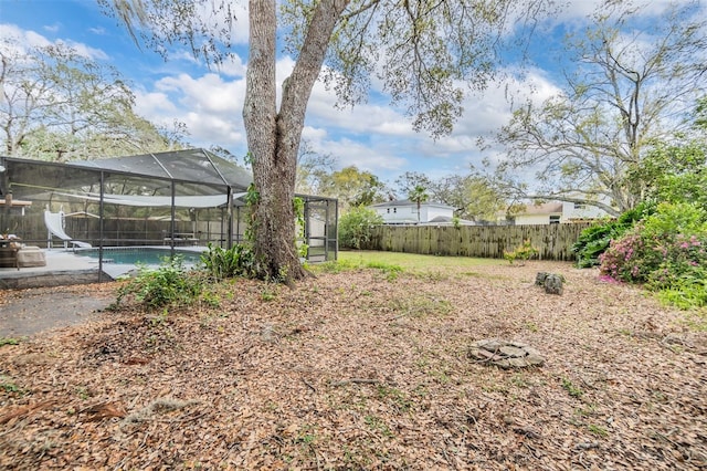 view of yard featuring a lanai, a fenced in pool, and a fenced backyard