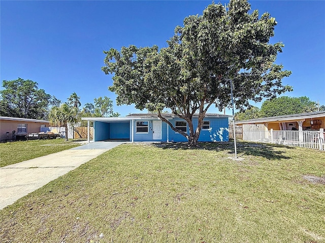 view of front of property featuring a carport, concrete driveway, a front yard, and fence