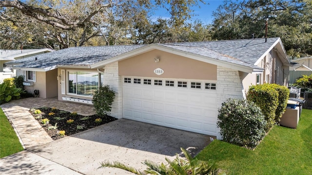 exterior space featuring an attached garage, stone siding, driveway, and stucco siding