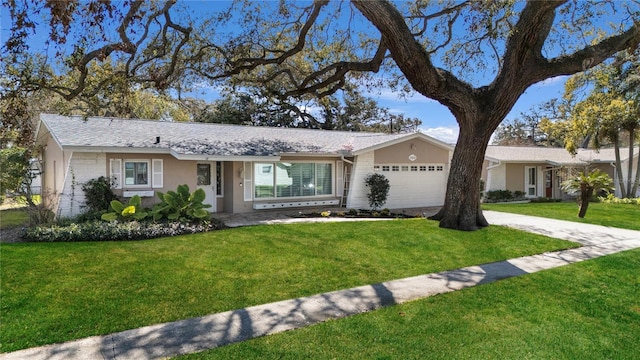 ranch-style house with a garage, concrete driveway, and a front lawn