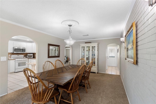 dining space with light tile patterned floors, arched walkways, light colored carpet, and a textured ceiling