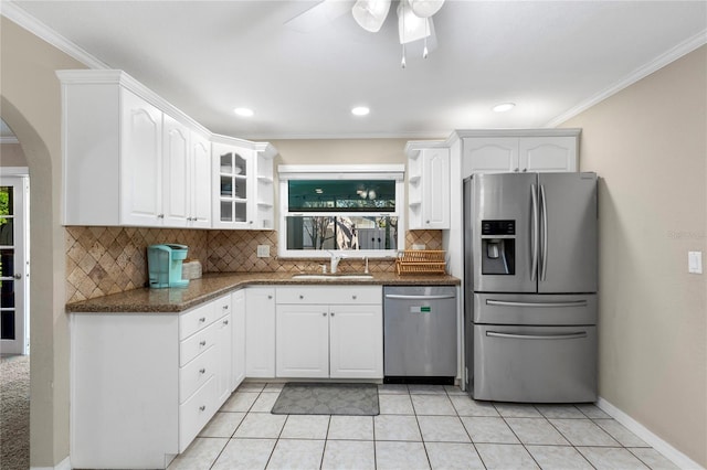 kitchen with a sink, appliances with stainless steel finishes, white cabinets, crown molding, and glass insert cabinets