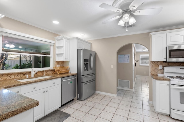 kitchen featuring visible vents, a sink, stainless steel appliances, arched walkways, and white cabinets