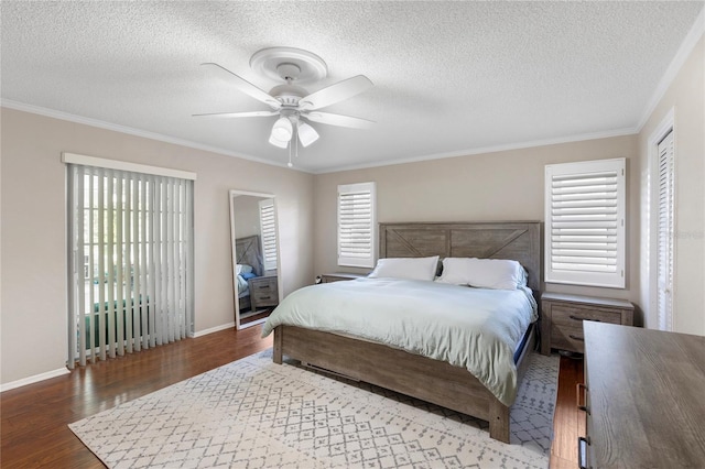 bedroom featuring baseboards, a textured ceiling, wood finished floors, and crown molding