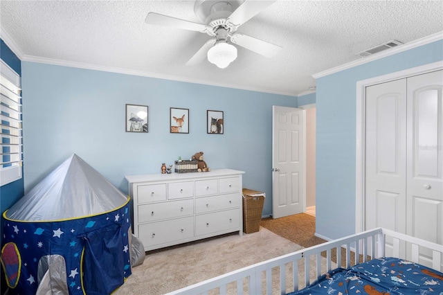 carpeted bedroom with visible vents, a textured ceiling, and ornamental molding