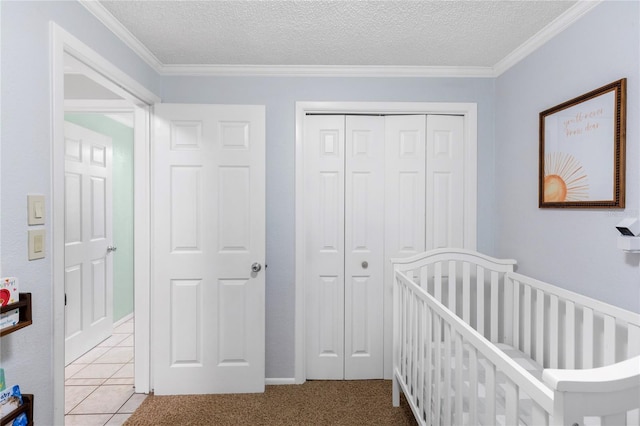 unfurnished bedroom featuring ornamental molding, a crib, a closet, a textured ceiling, and carpet flooring