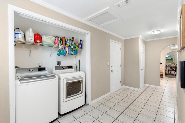 clothes washing area with visible vents, attic access, laundry area, arched walkways, and washer and dryer