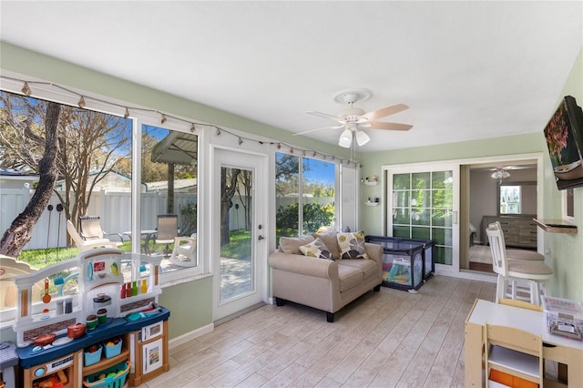 sunroom / solarium featuring ceiling fan