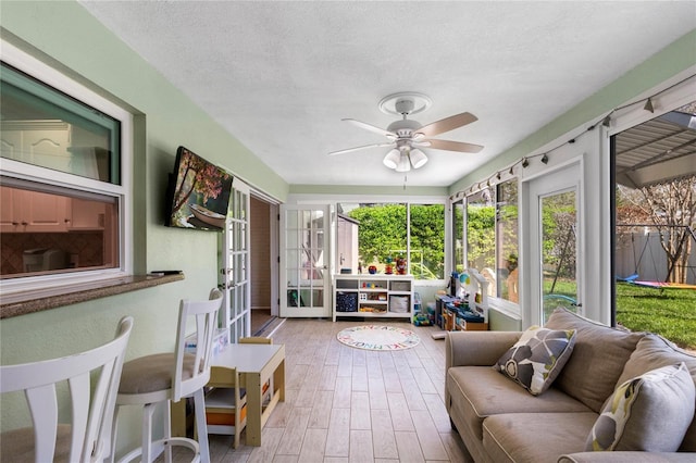 sunroom / solarium with a ceiling fan