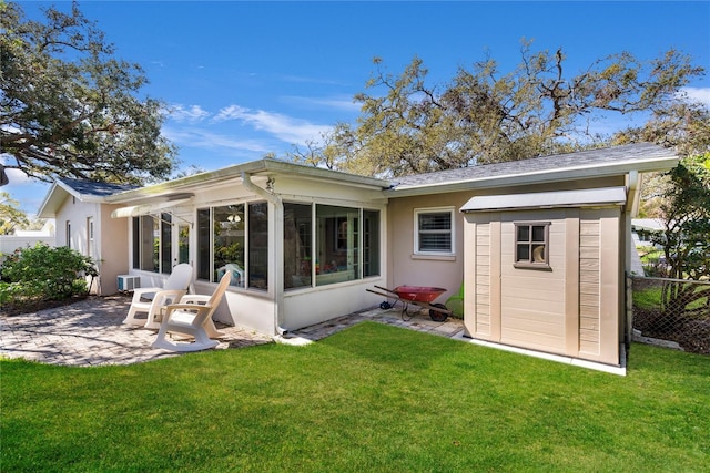 back of property with a yard, a patio area, fence, and a sunroom