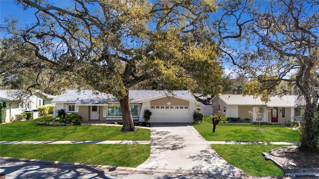 single story home featuring a front lawn, a garage, and driveway