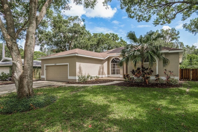 view of front of property featuring a front yard, fence, an attached garage, stucco siding, and concrete driveway