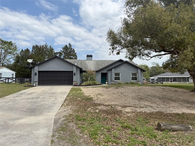 view of front of property with a garage, driveway, a chimney, and stucco siding