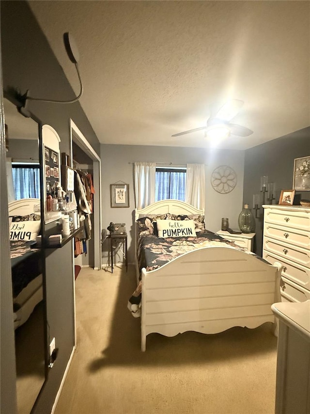 bedroom featuring ceiling fan, carpet floors, and a textured ceiling