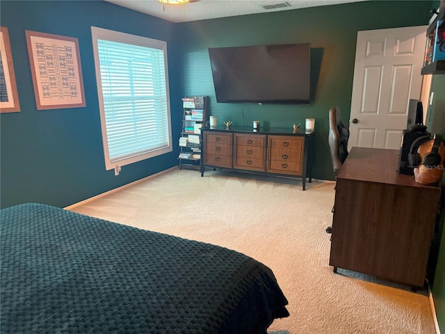 bedroom featuring visible vents, light colored carpet, and baseboards