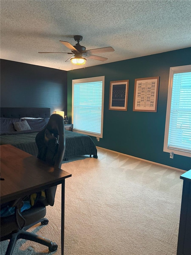 bedroom featuring a textured ceiling, baseboards, a ceiling fan, and carpet floors