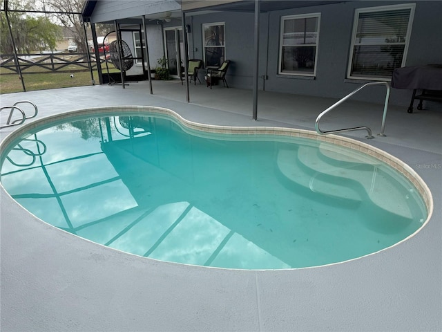 outdoor pool with a lanai and a patio area