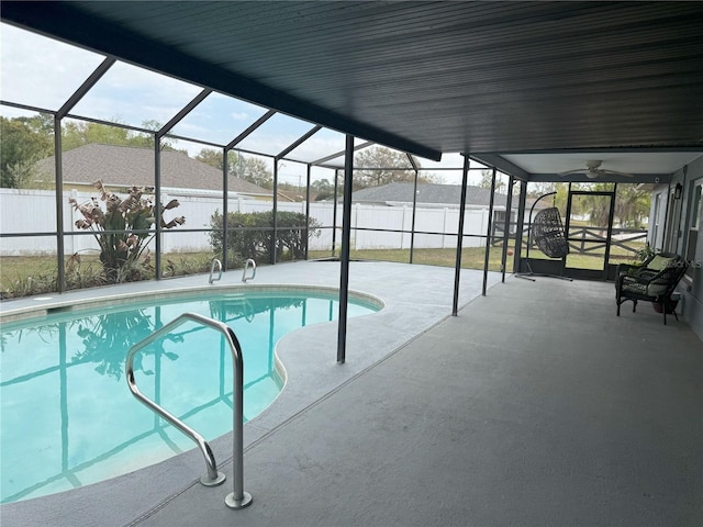 view of swimming pool featuring glass enclosure and a fenced backyard