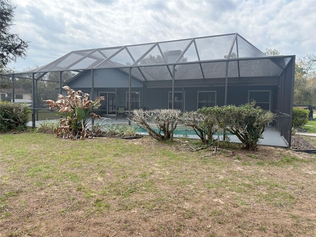 rear view of house featuring a lanai, an outdoor pool, a patio, and a yard