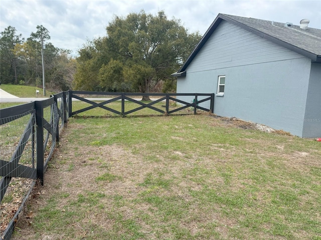 view of gate with a yard and fence