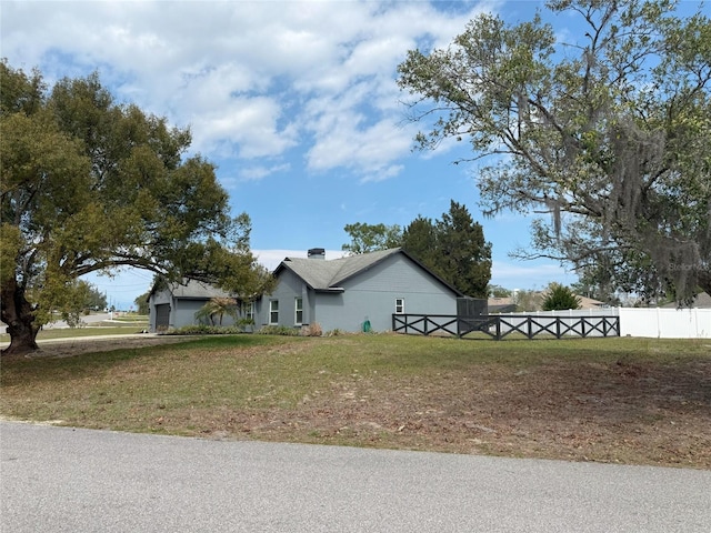 view of front of home featuring a chimney, a front yard, and fence