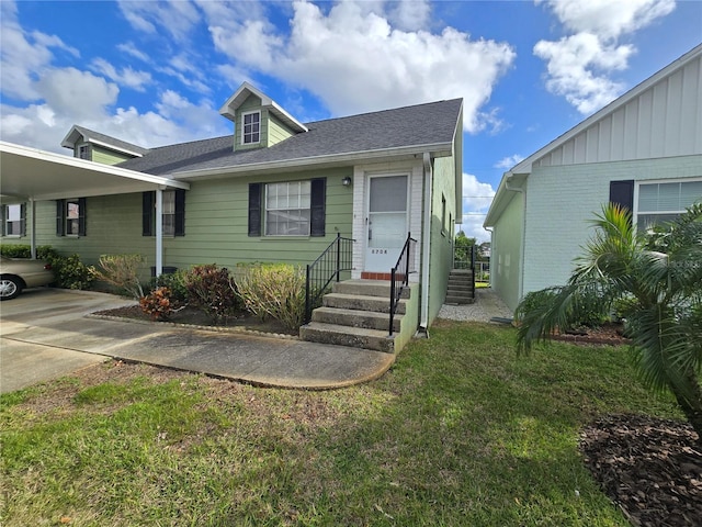 view of front of house featuring an attached carport, entry steps, a shingled roof, and a front yard