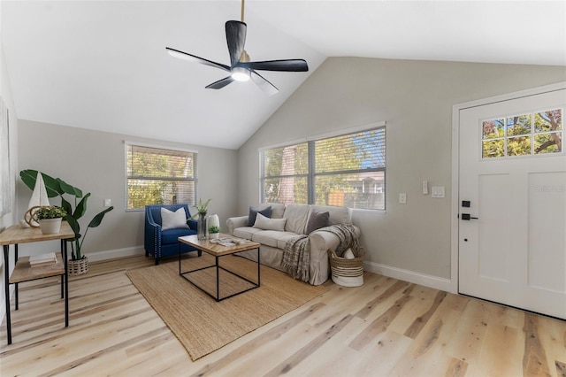 living room featuring baseboards, lofted ceiling, light wood-style floors, and ceiling fan